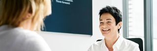 Portrait of young man sitting at his desk in the office; Shutterstock ID 648506098