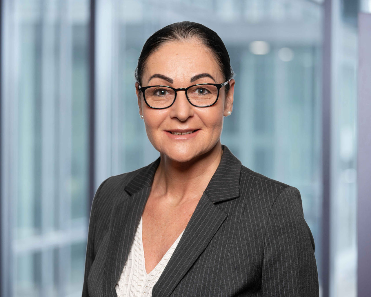 Photo de la directrice des ressources humaines C. Vegliante sur un fond de bureau flou.