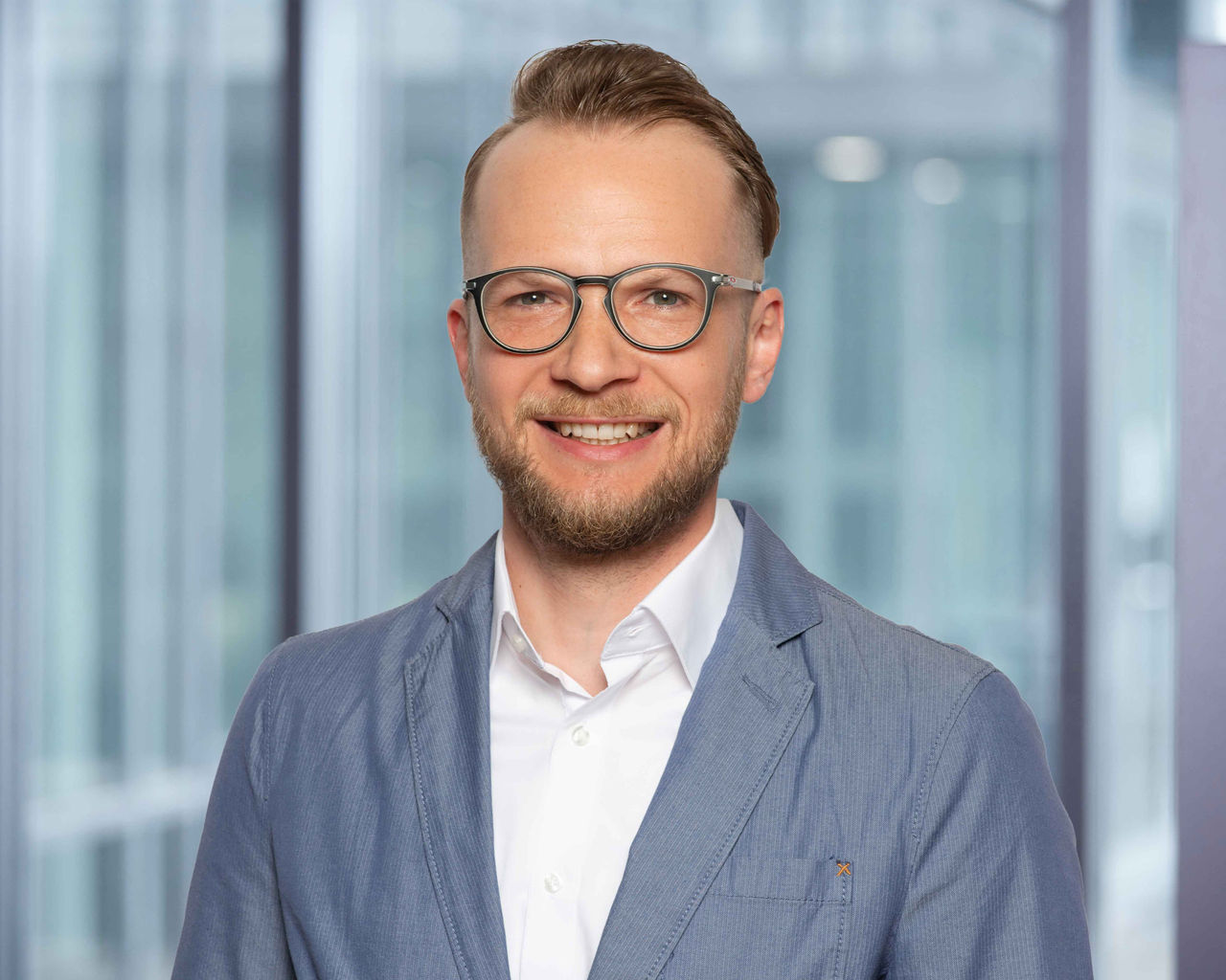 Photo du responsable des relevés et de la facturation S. Fenkl sur un fond de bureau flou.