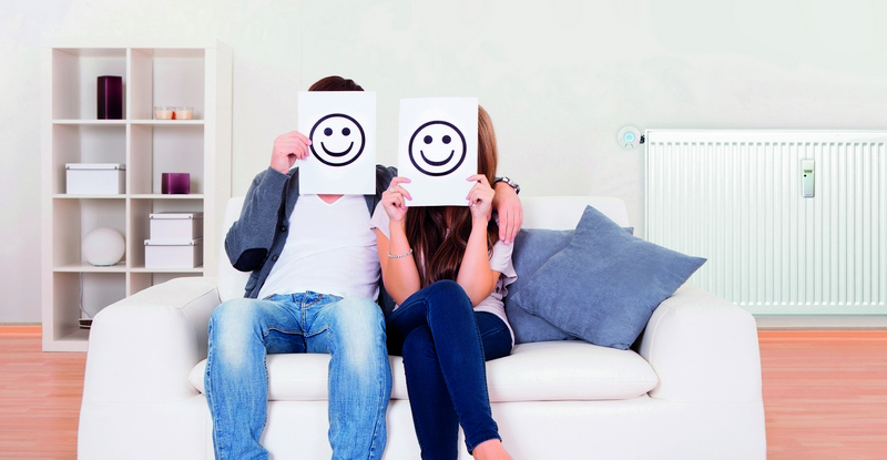 Couple covered faces with smiley white paper.; Shutterstock ID 120403153