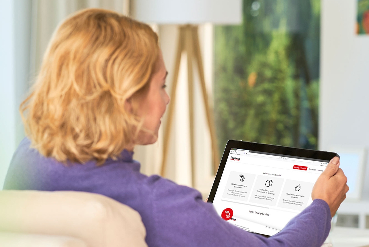 Kvinde sidder med en tablet, som viser data om ejendommen. 