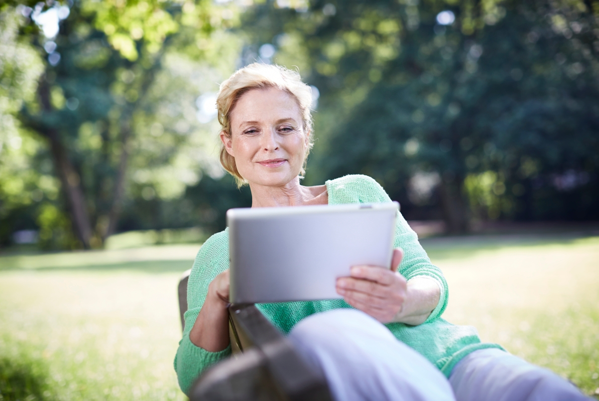 Reife Frau benutzt einen Tablet-PC auf der Parkbank [(c) F1online www.f1online.de, Tel. 069/80069-0, E-Mail:agency@f1online.de ]