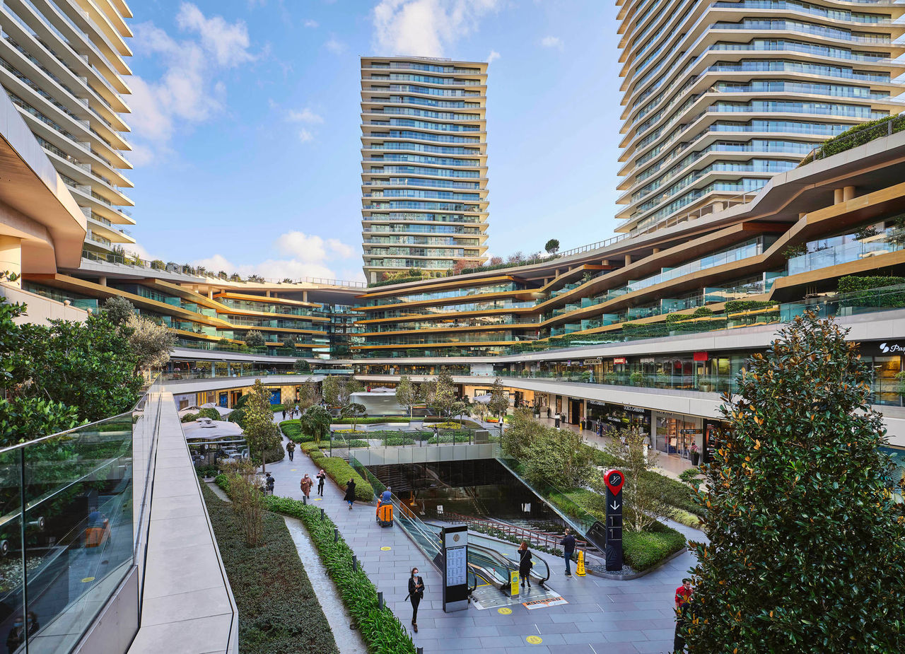 Complesso di grattacieli, in un ambiente moderno, con spazi verdi all'aperto. Nel complesso è situato anche un centro commerciale.