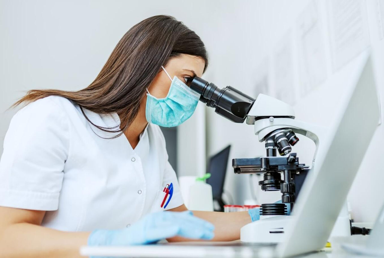 Eine Frau im Labor führt eine Legionellenprüfung durch.
